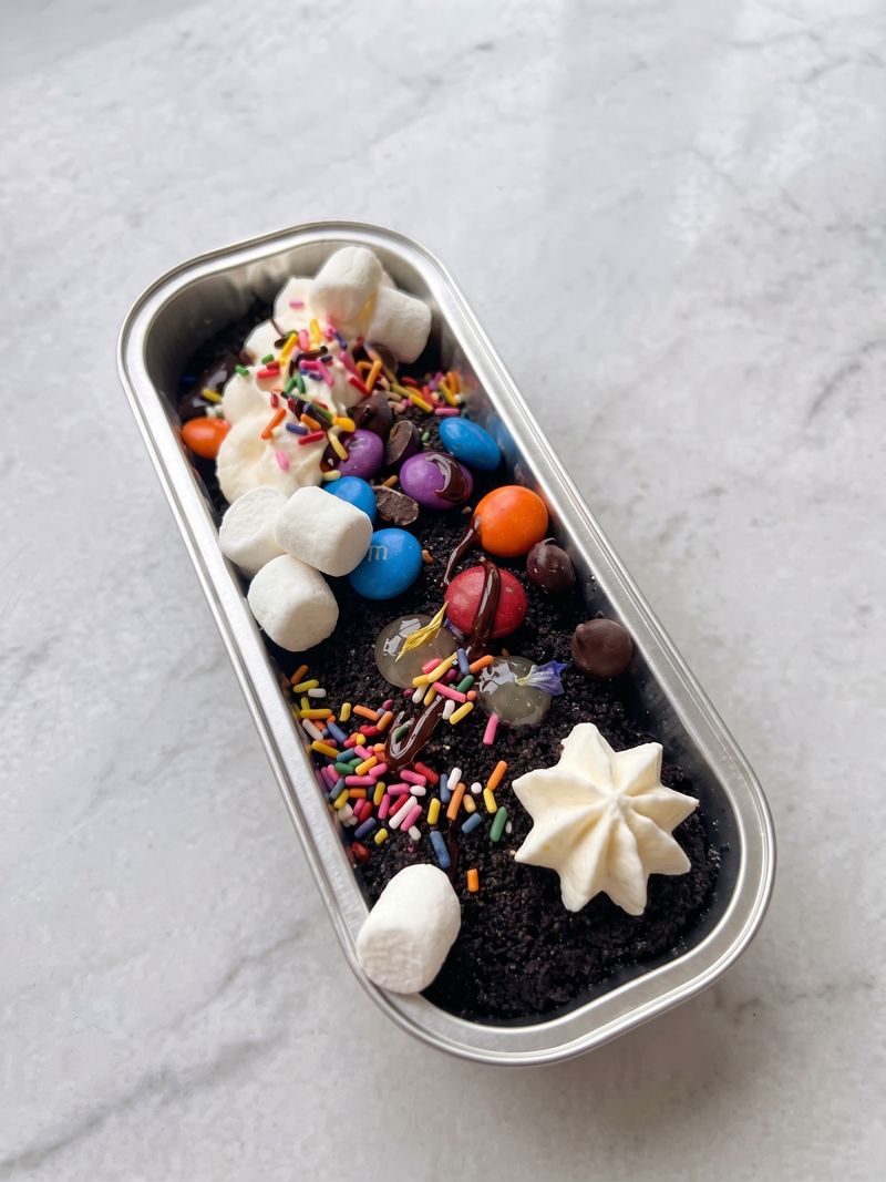 Cake tub topped with M&M's, sprinkles, marshmallows and whipped cream