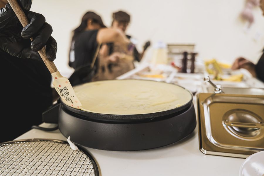 Crepe batter spreading on the griddle at the crepe bar